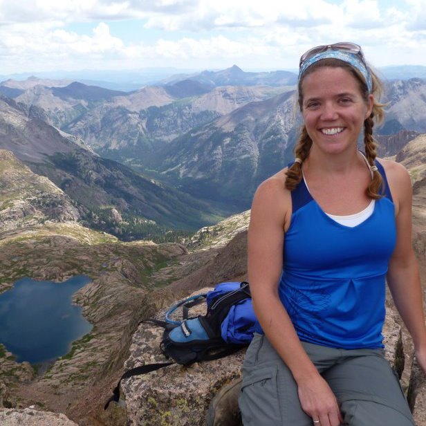 Katrina Kirsch on a summit above an alpine lake
